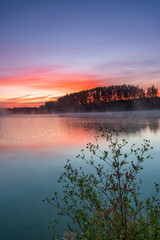 Dawn landscape on the lake. Early foggy mornings with beautiful skies and clouds. The colors of dawn and fog.