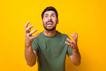 Fototapeta premium Photo of furious abusive guy dressed green t-shirt screaming looking up empty space isolated yellow color background