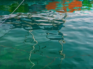 Boat and boat water reflexion in water. Abstract distorted boat elements in water. Blue water...