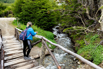 woman contemplating and walking through beautiful landscape of mountains forests rivers and bridges...