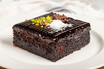 Moist chocolate cake dessert. Slice of milk and chocolate cake on wooden serving board. local name islak kek