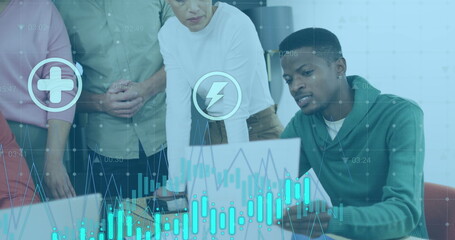 Image of icons, graphs over diverse man explaining reports to coworkers on laptop in office