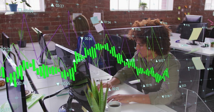 Image of multiple graphs with changing numbers over biracial man working on computer in office
