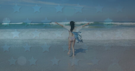 Image of American flag waving over woman running on beach by seaside on summer holiday in the backgr