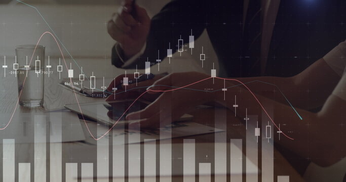 Digital composite of a man and woman discussing while using a touchscreen tablet and graphs move in
