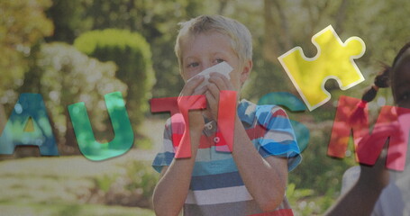 Image of colourful puzzle pieces and autism text over kids friends sneezing nose