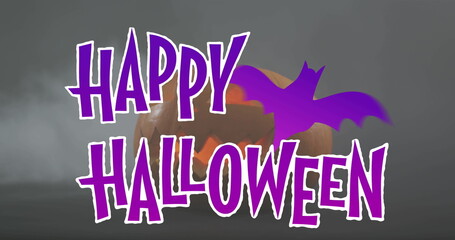 Fototapeta premium Image of happy halloween text with bat over orange carved pumpkin