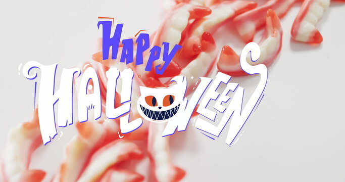 Naklejki Image of happy halloween text with cat over teeth sweets