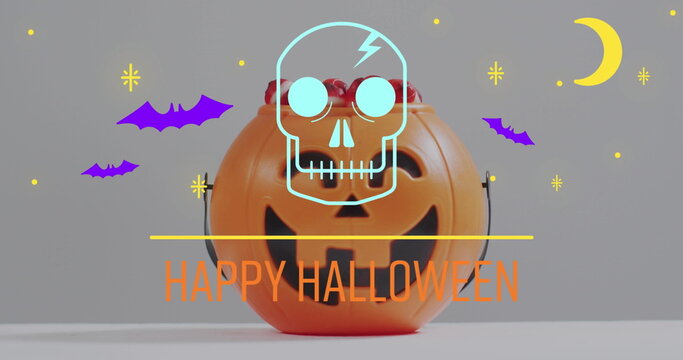 Naklejki Image of happy halloween text with ghosts over orange pumpkin bucket with sweets