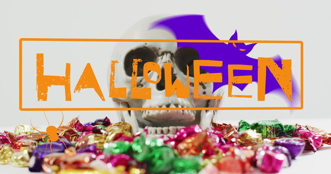 Image of happy halloween text over skull and sweets