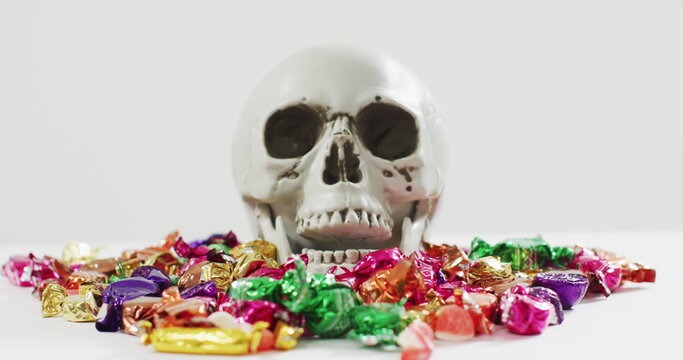 Naklejki Image of happy halloween text over skull and sweets