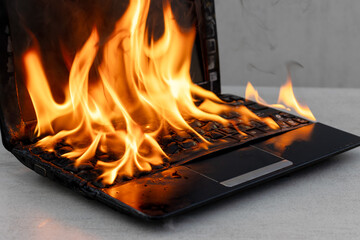 An open laptop burning in a fire close-up