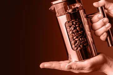 Tuinposter Glass brew with coffee grains on the woman's palm. Morning with fresh coffee. Making coffee. © Evgenii