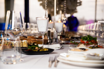 Serving the festive table at a wedding event. Decorating the wedding table with bouquets of flowers. Cutlery at a party