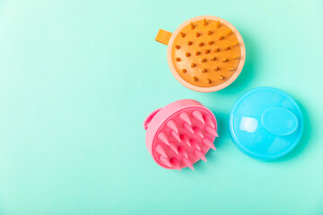 Brush for scalp massage on a mint background. Brush for hair growth stimulating brush. Hair massage. stimulating brush. Hair care, head relaxation concept. Copy space.