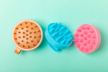 Brush for scalp massage on a mint background. Brush for hair growth stimulating brush. Hair massage. stimulating brush. Hair care, head relaxation concept. Copy space.