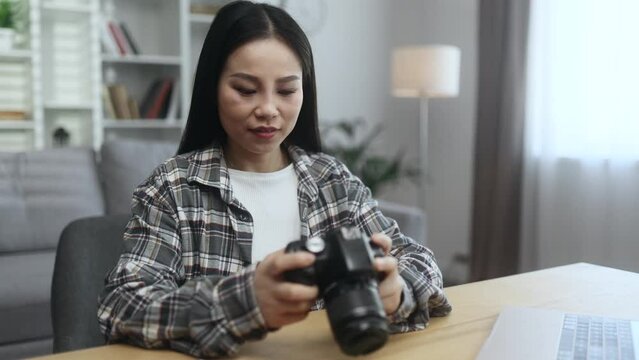 Portrait of sad young asian woman photographer dissatisfied her photos at camera and expressively throw it away at home workplace Lack of inspiration and creative crisis concept