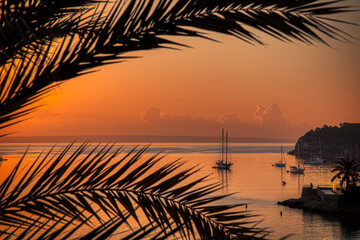 Dawn rising over a small yachts moored in a tropical bay