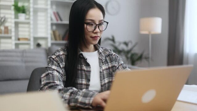 Pretty young asian woman freelancer working on laptop checking email surfing web indoors Smiling female student having online distance education or work on computer and looking at screen at home