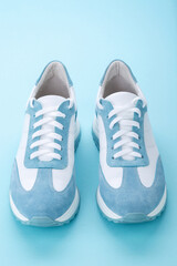 Pair of blue sneakers on blue background