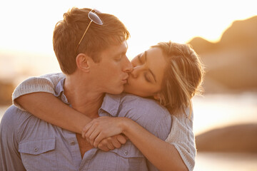 Couple, kiss and love in hug at beach, ocean waves and peace for romance in relationship. People,...