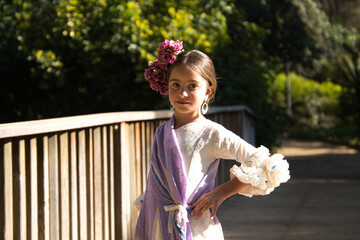 Portrait of a pretty girl dancing flamenco in a dress with frills and fringes typical of gypsies,...