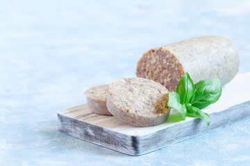 Traditional Irish white or oatmeal pudding sausage slices on a wooden board, horizontal copy space