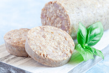 Traditional Irish white or oatmeal pudding sausage slices on a wooden board, horizontal