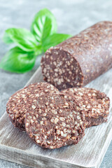 Traditional Irish and British black pudding sausage slices on a wooden board, vertical