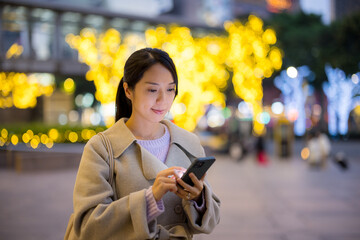 Asian woman use mobile phone in city at night - 758113092