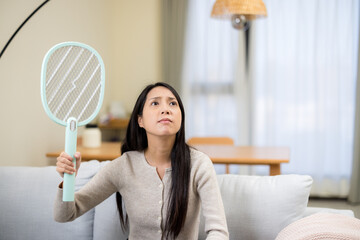 Woman use mosquito swatter at home - 758113408