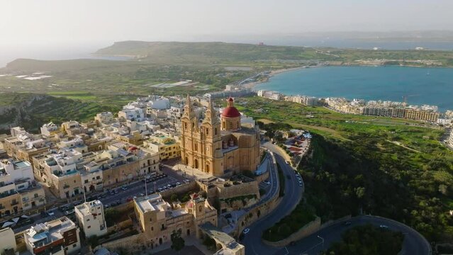 The Parish Church in Mellieha city and road. Blue sky, sea, day. Landscape drone view. Maltese island