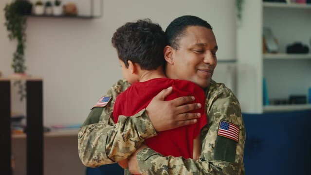 Excited boy running to hug his soldier father who's come back from the military