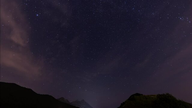 video timelapse, con ampia visuale panoramica, che mostra il cielo parzialmente sereno e stellato, di notte e la rotazione terrestre