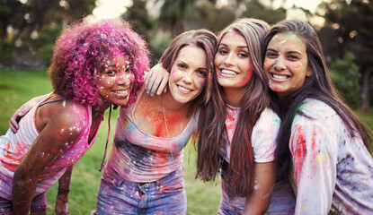 Friends, group hug and color festival in park, fun with powder paint for celebration or party...