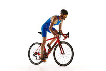 Athletic young man, cyclist in uniform, helmet and goggles in motion, riding bike isolated on white studio background. Concept of sport, active and healthy lifestyle, speed, endurance, hobby