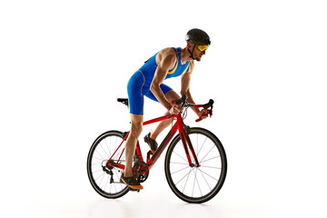 Fototapeta premium Athletic young man, cyclist in uniform, helmet and goggles in motion, riding bike isolated on white studio background. Concept of sport, active and healthy lifestyle, speed, endurance, hobby