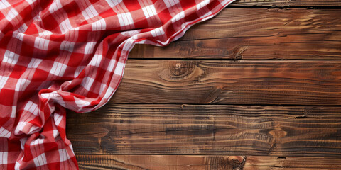 A red and white checkered tablecloth lies on a wooden background with copy space, banner