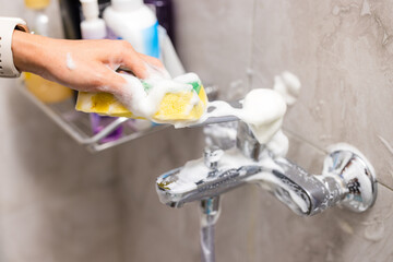Cleaning hard water stains deposits on bath tap at toilet - 758123488