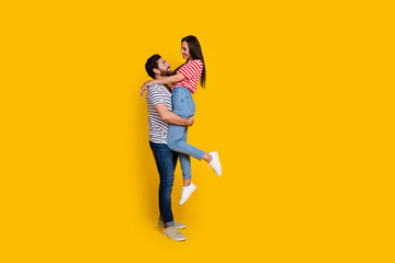 Fototapeta na wymiar Full length photo of strong handsome boyfriend look at his lovely girlfriend hold on hands isolated on vivid yellow color background