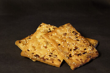 Cereal cookies with seeds close-up on a black background, three cookies with cereals healthy food, cereal cookies on a black background