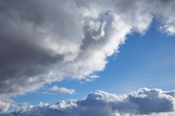 Large cumulonimbus rain clouds cover the blue sky