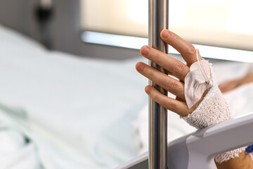Medicine and health. A woman's hand with a bandage and an intravenous line, in a hospital bed....