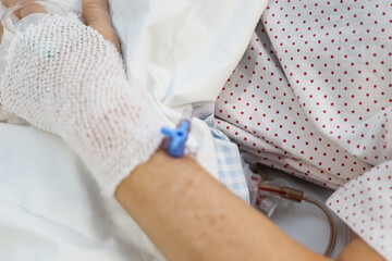 Medicine and surgery. Space for text. Hand of a patient with an intravenous line and drainage tube.