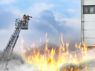 Firefighter Battles Intense Blaze from Aerial Ladder Above Inferno