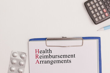 Office scene with documents with text "Health Reimbursement Arrangements" neatly placed on a desk