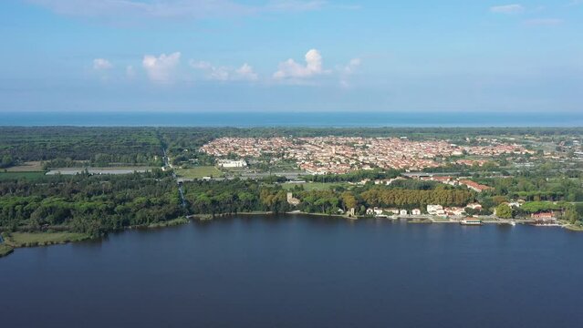 Beautiful drone view of Torre del Lago Puccini on the coast of Tuscany with Apuane Alps and a clear blue sky of a spring day, with Massaciuccoli Lake and Mediterranean Sea