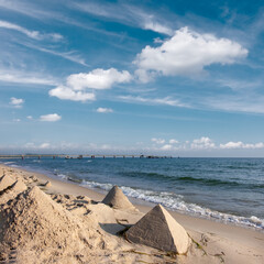 A sandy beach with several sand pyramids created on the shore. Romantic shores of Baltic sea.