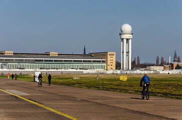 Berlin, Germany, March 8, 2024: people wlaking and bicycling on the runway of former TEmpelhof airport on a sunny day in spring