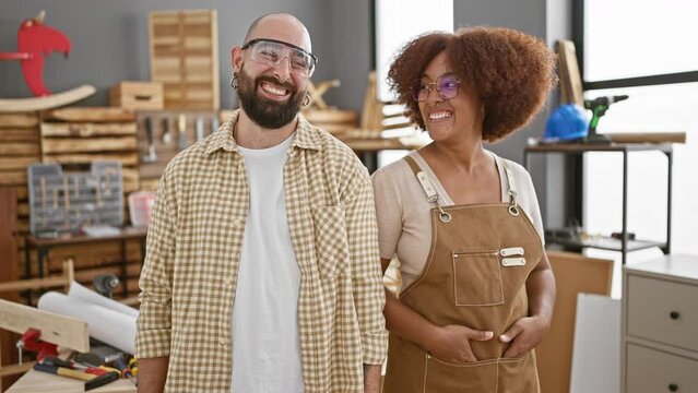 Two smiling carpenters, clad in safety glasses, standing united at their heartwarming carpentry workshop